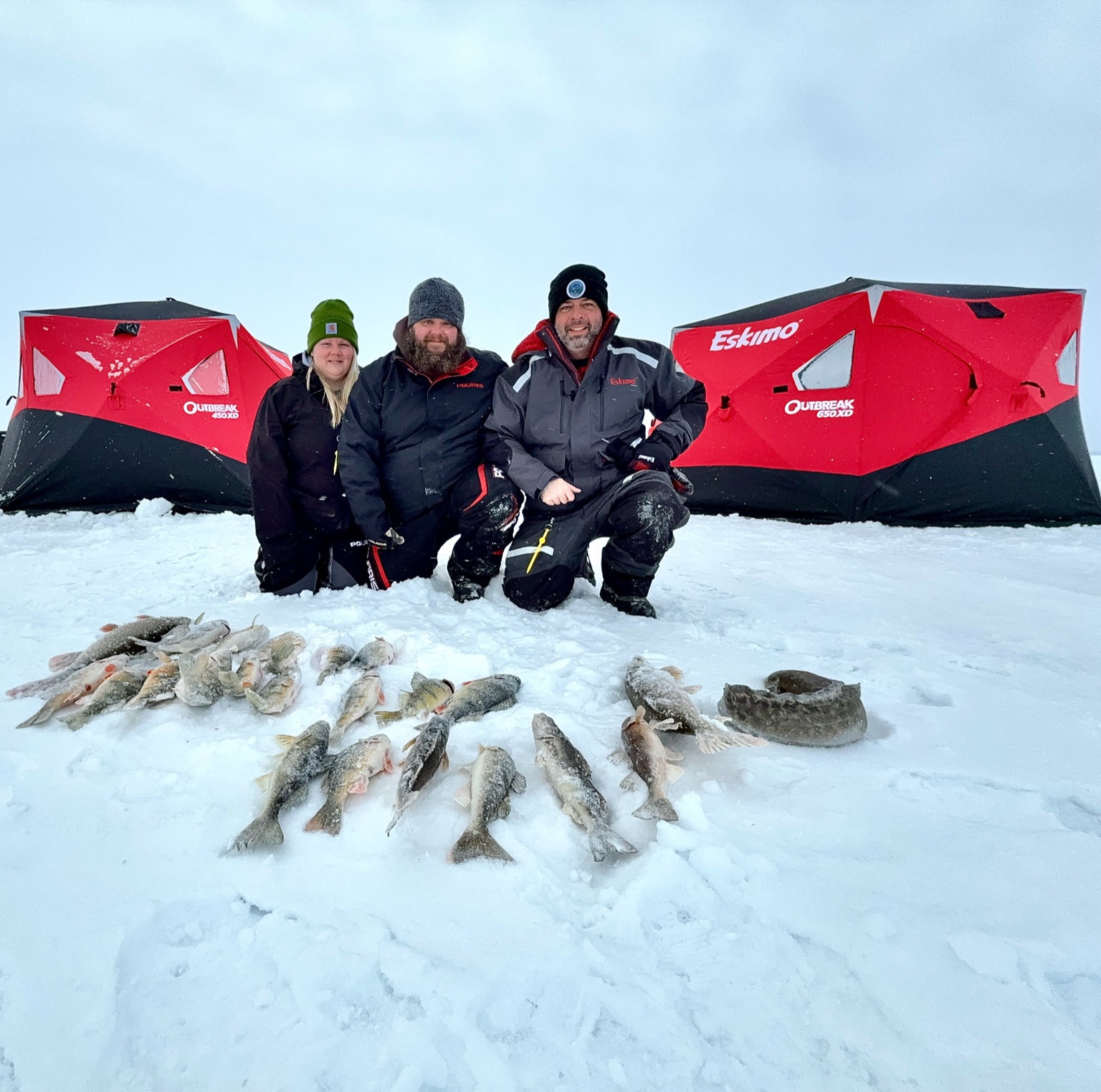 Cold Vision Outdoors crew on the ice with a pile of fish